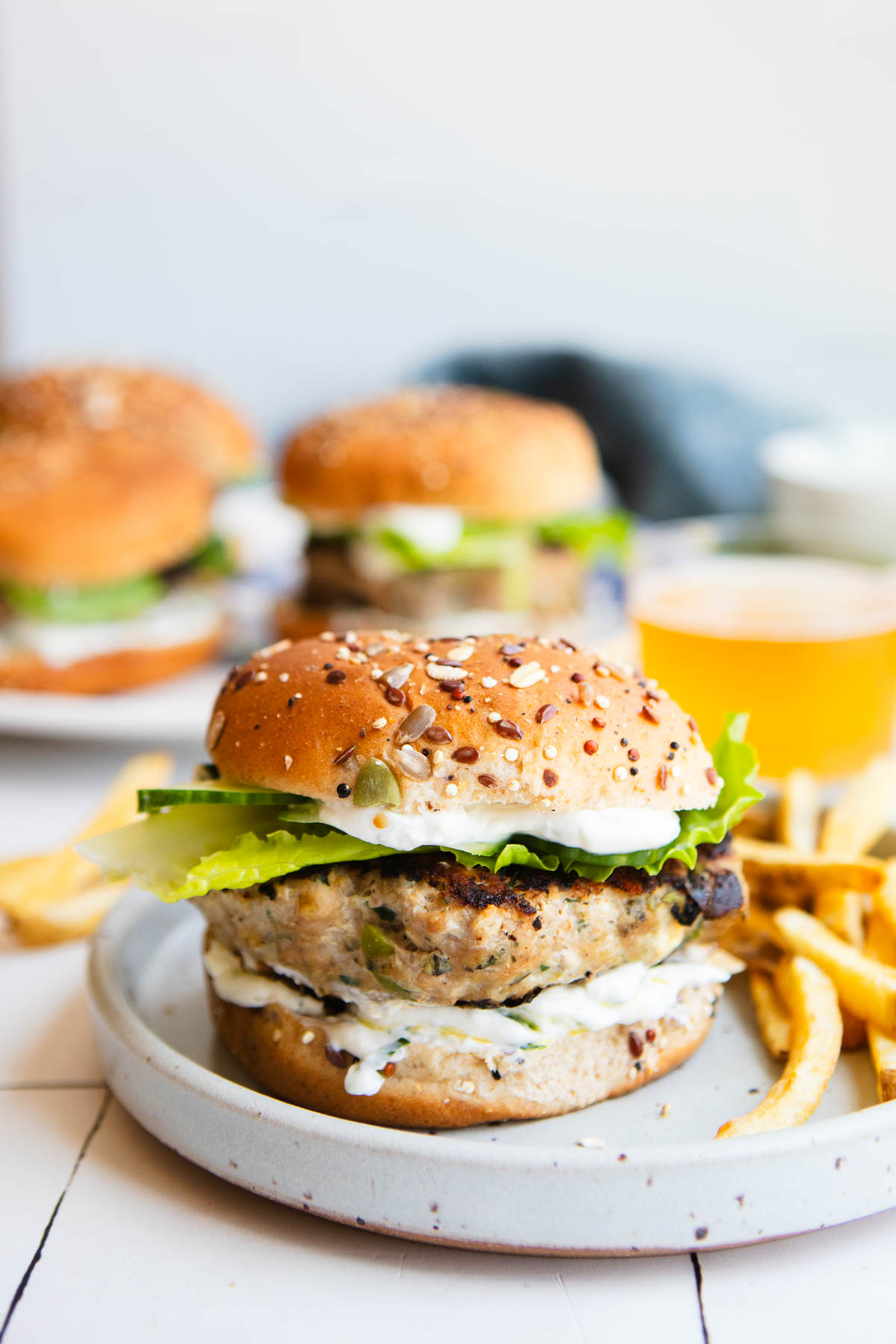 ground turkey burgers with a Greek yogurt dressing and toasted bun next to French fries