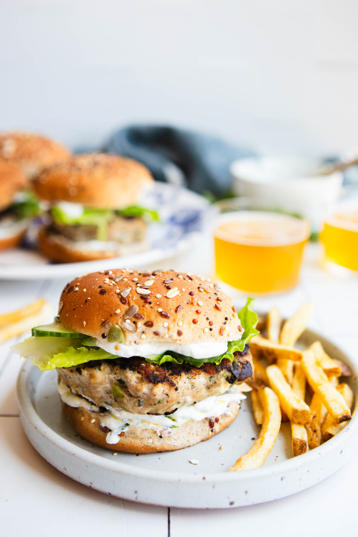 greek turkey burgers served on a bun with lettuce and cucumber and yogurt sauce