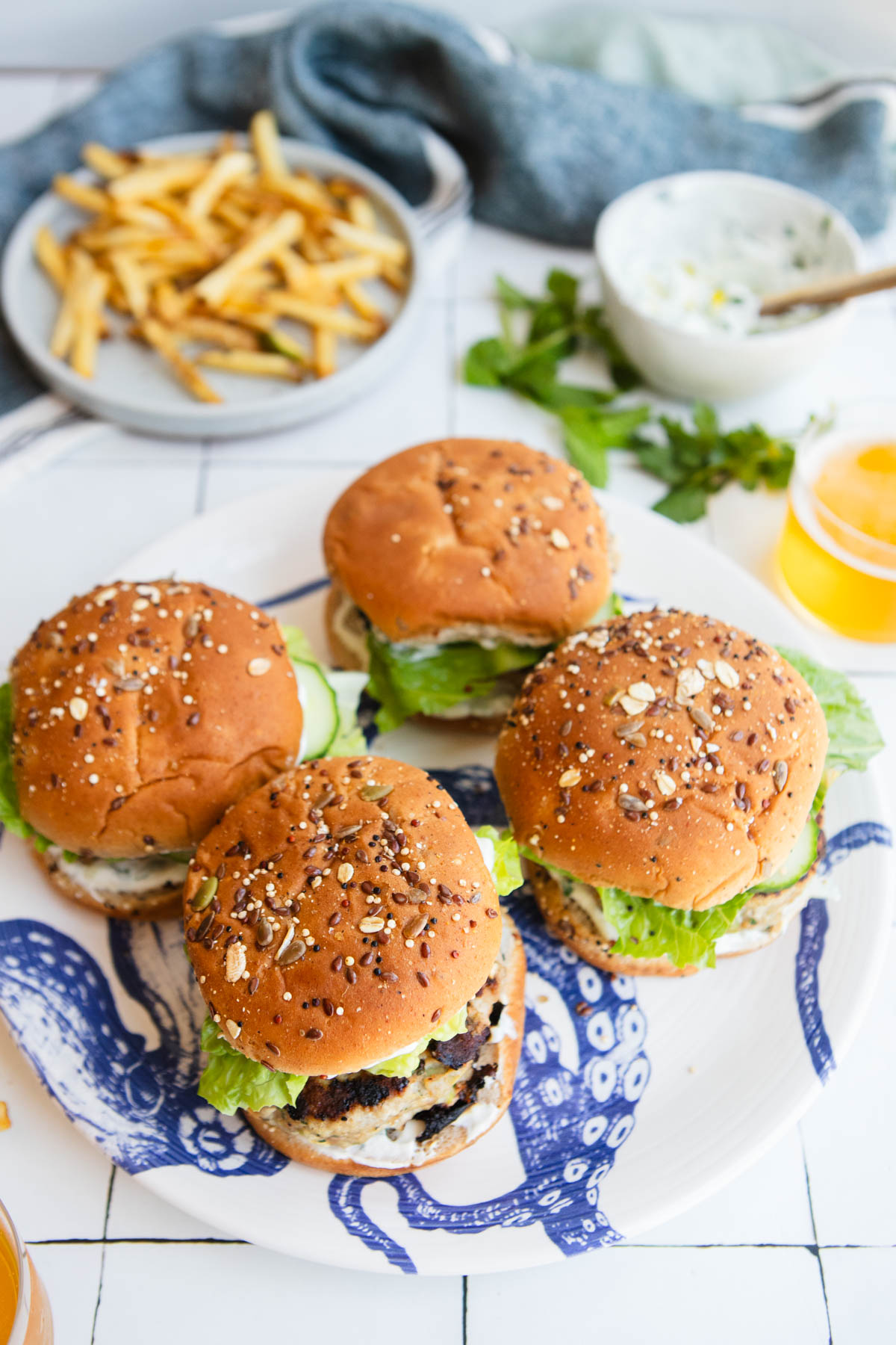 a platter of grilled ground turkey burgers on a white and blue serving plate