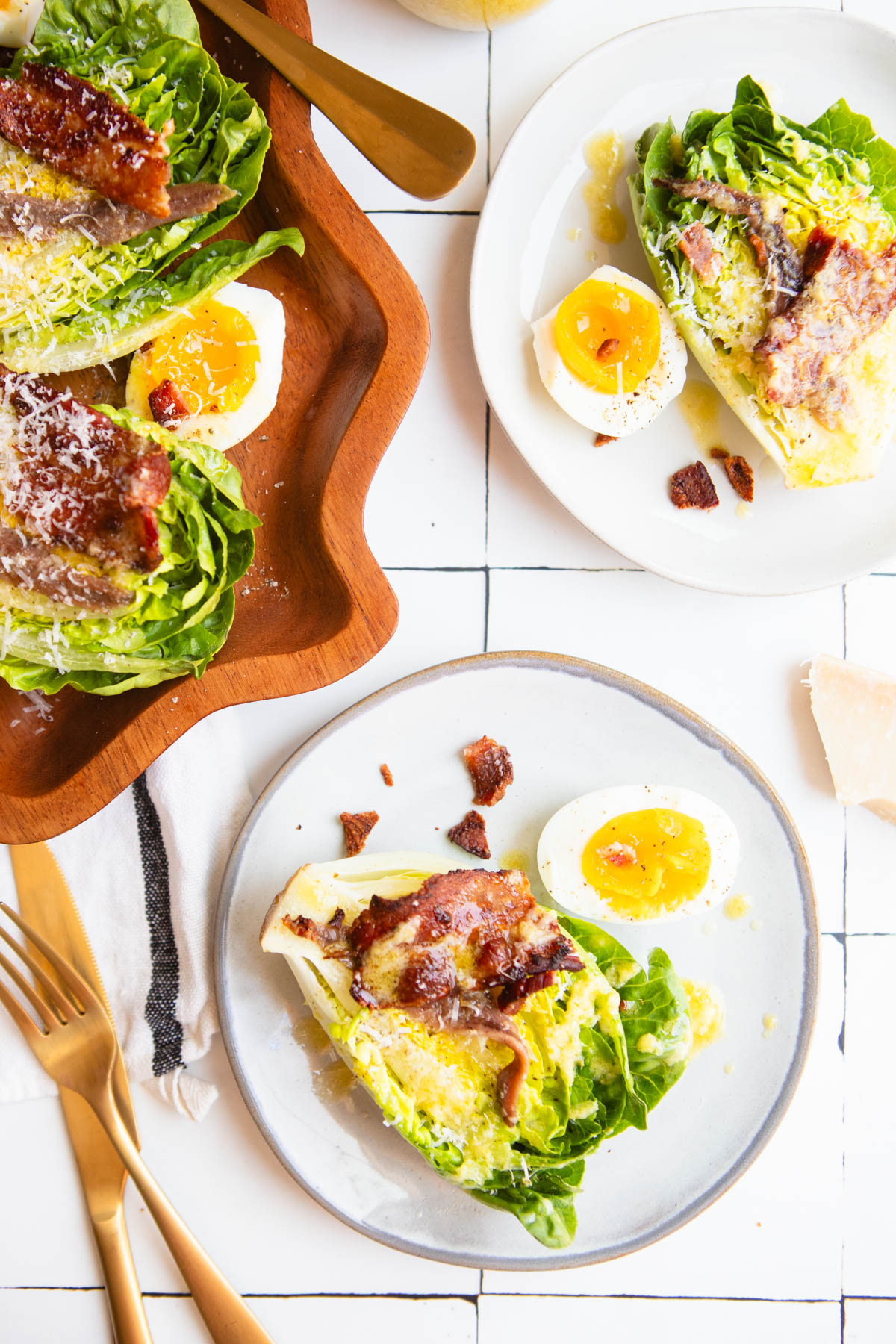 French bistro salad served on beige plates and garnished with crispy bacon bits