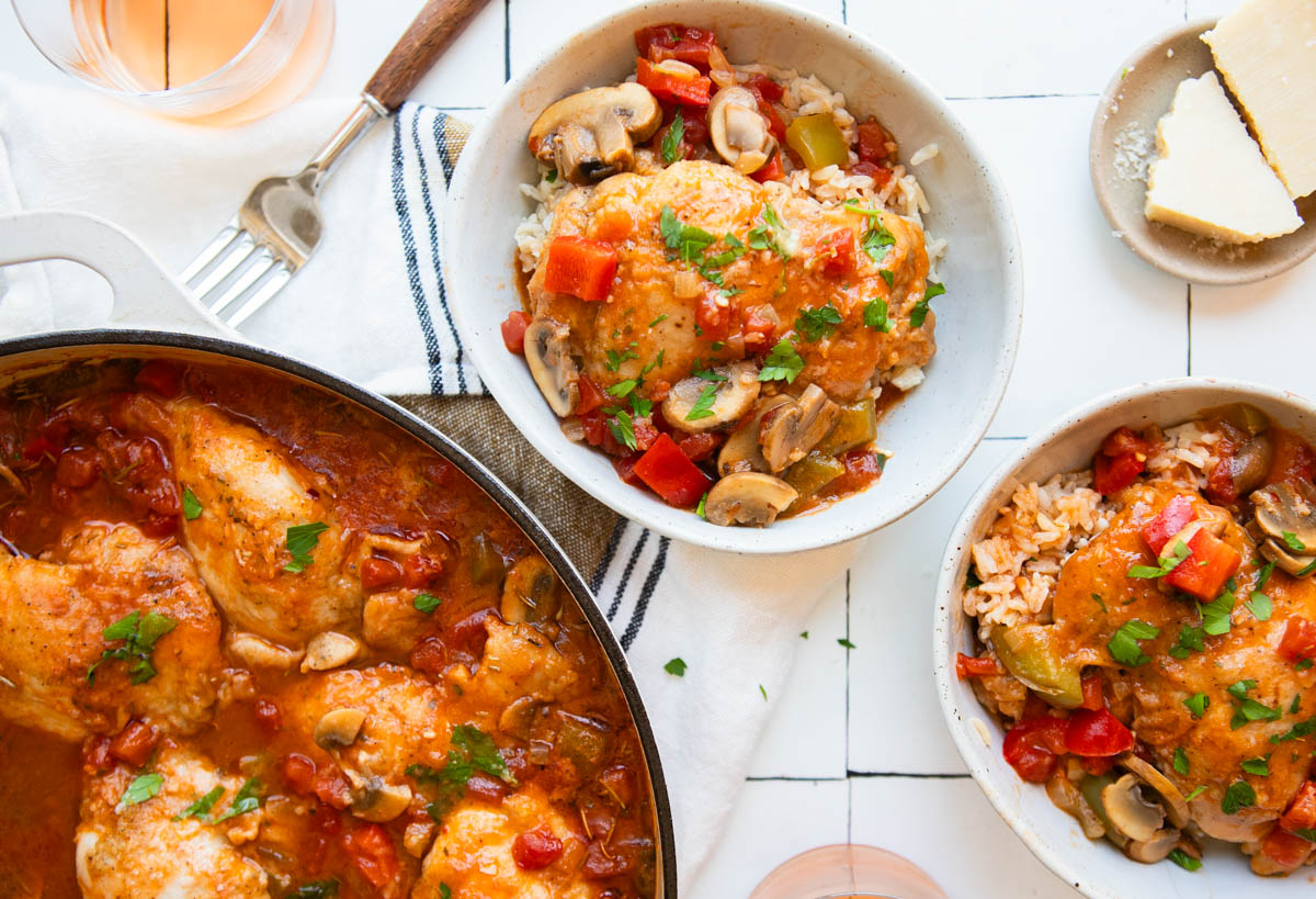 chicken cacciatore served over a bowl of long grain brown rice and topped with parsley and shredded parmesan 