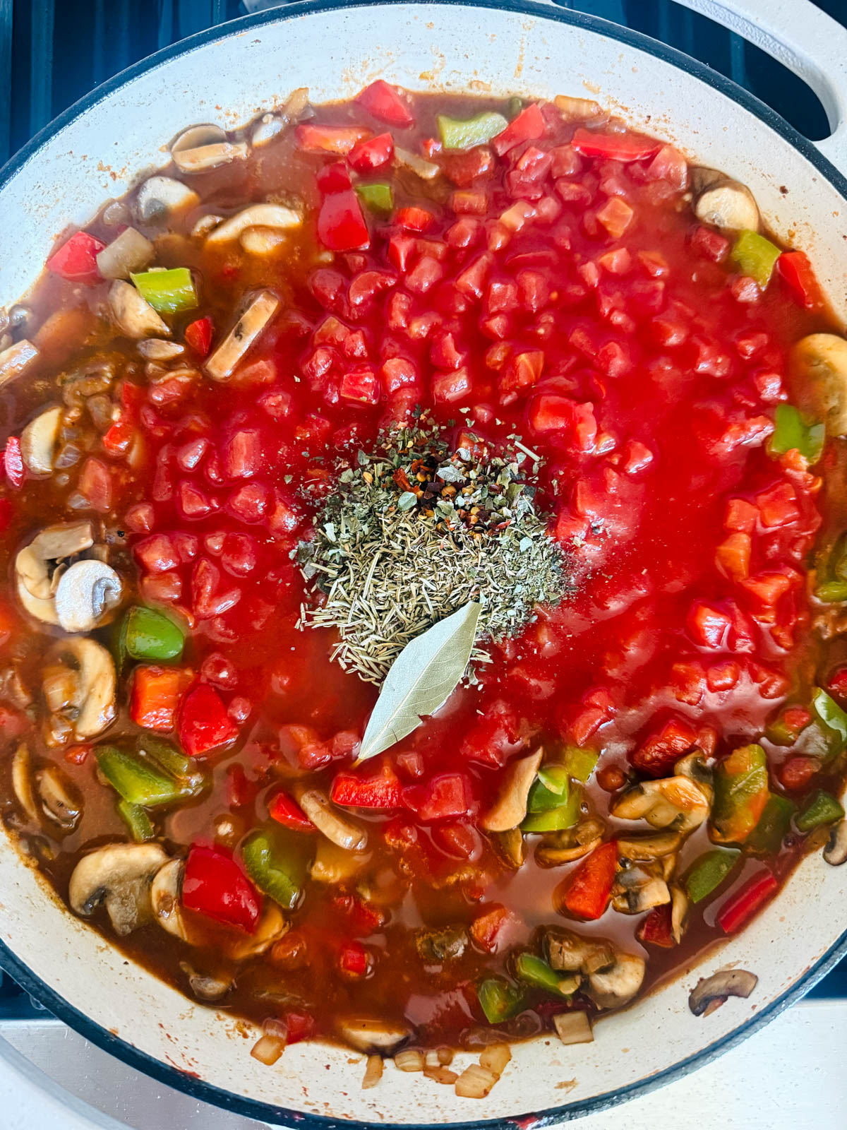 diced tomatoes and dried herbs added to pan of veggies 