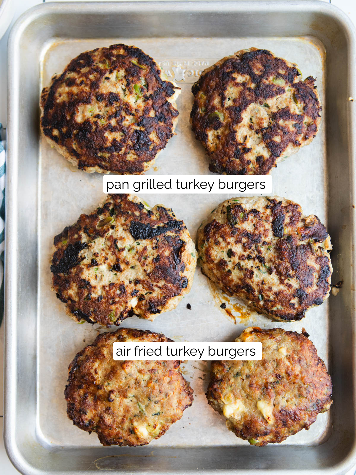 sheet pan with both pan grilled turkey burgers and air fried turkey burgers to show the difference in shape and color 