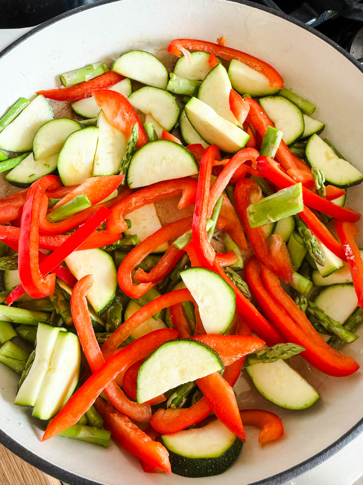 peppers and zucchini sautéing in a pan
