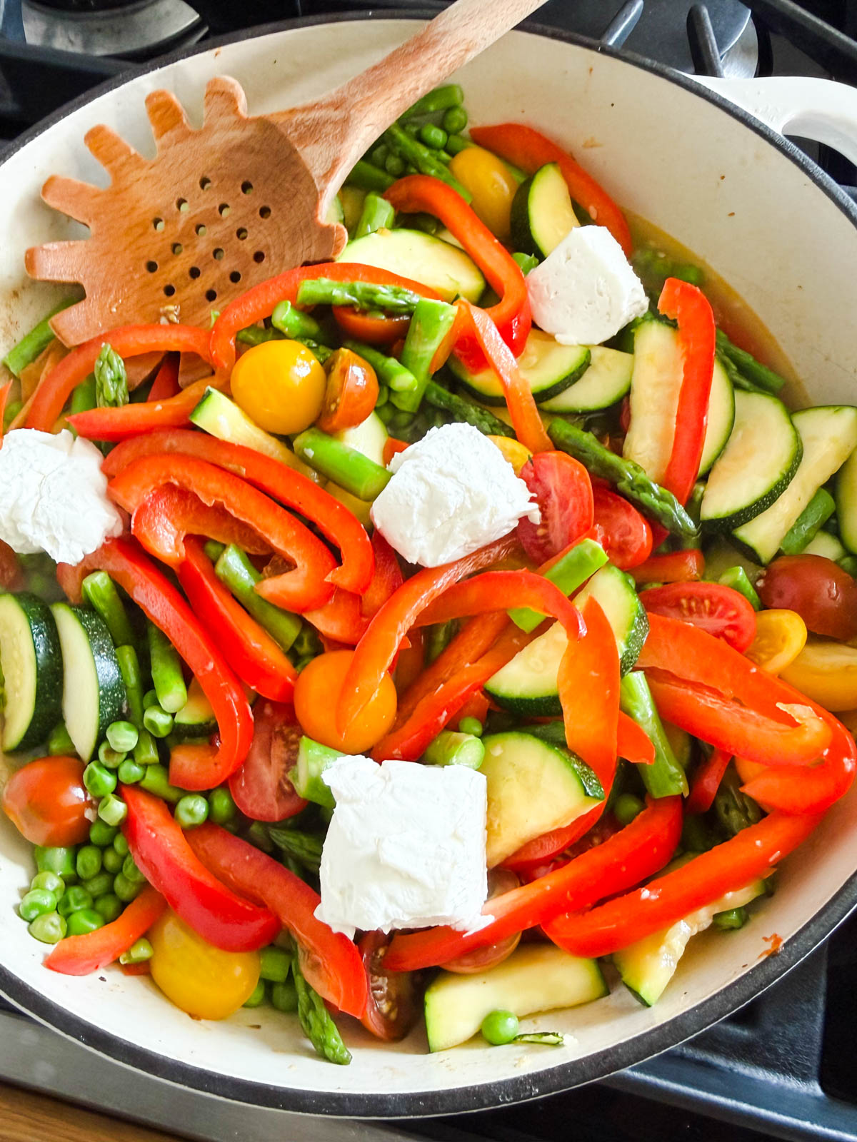 cream cheese added to a pan of veggies to make pasta primavera