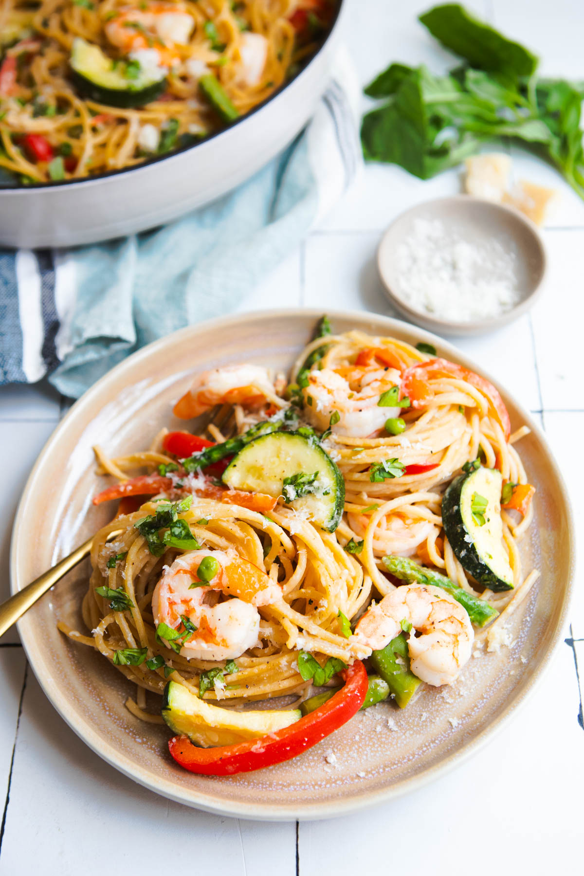 pasta primavera with shrimp on a beige plate