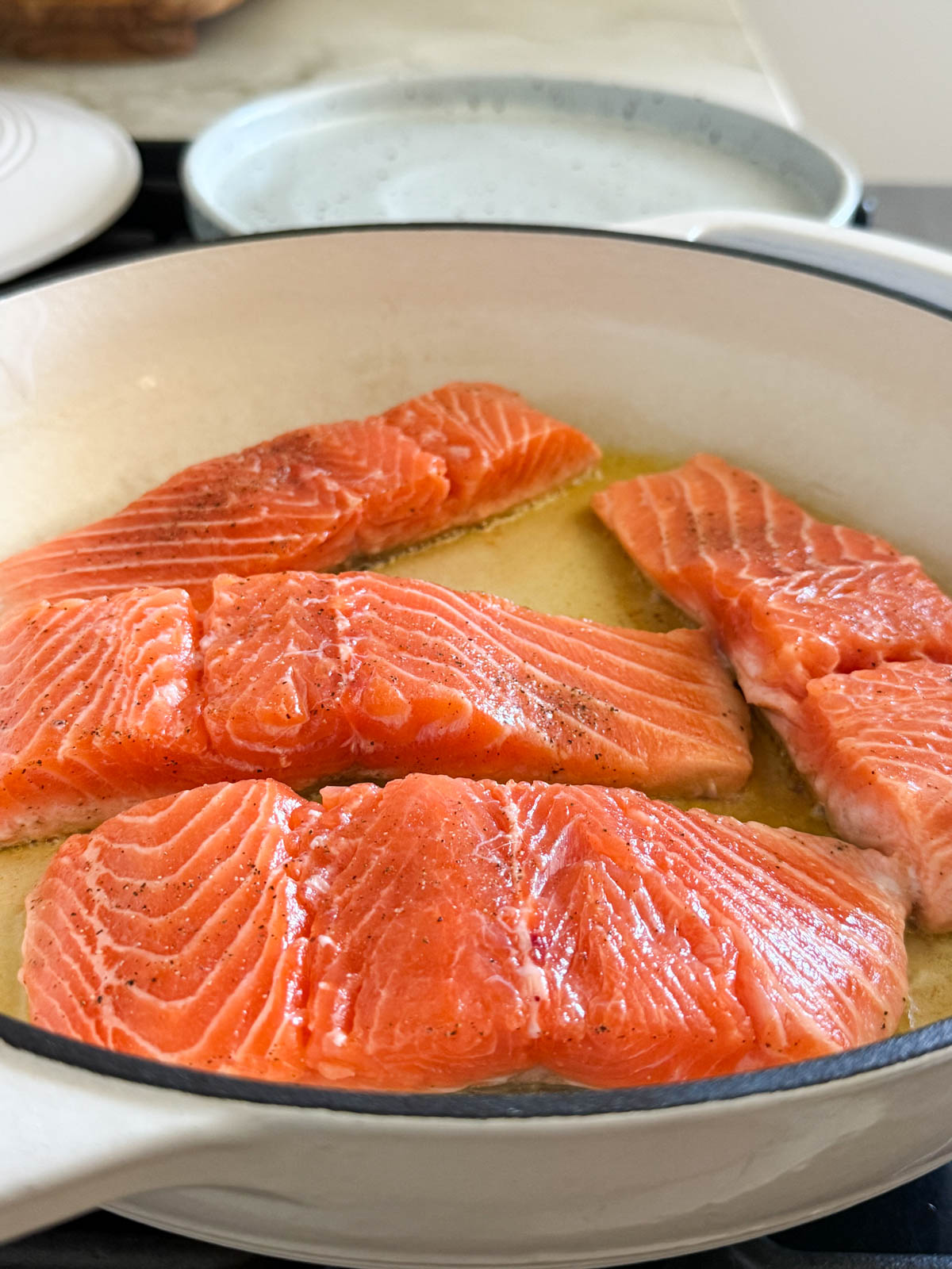 salmon filets cooking in a pan on the stovetop