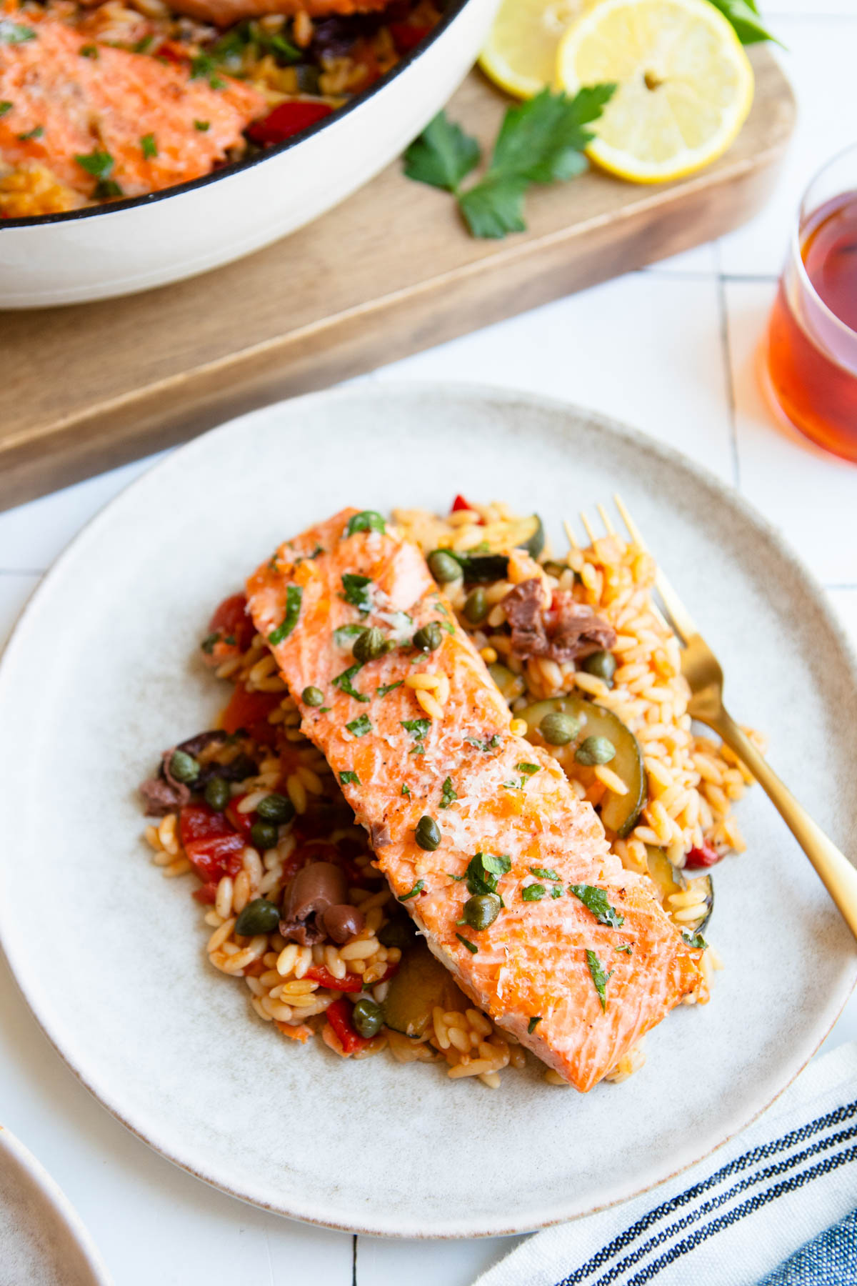 a plate of Mediterranean salmon and orzo next to a gold fork