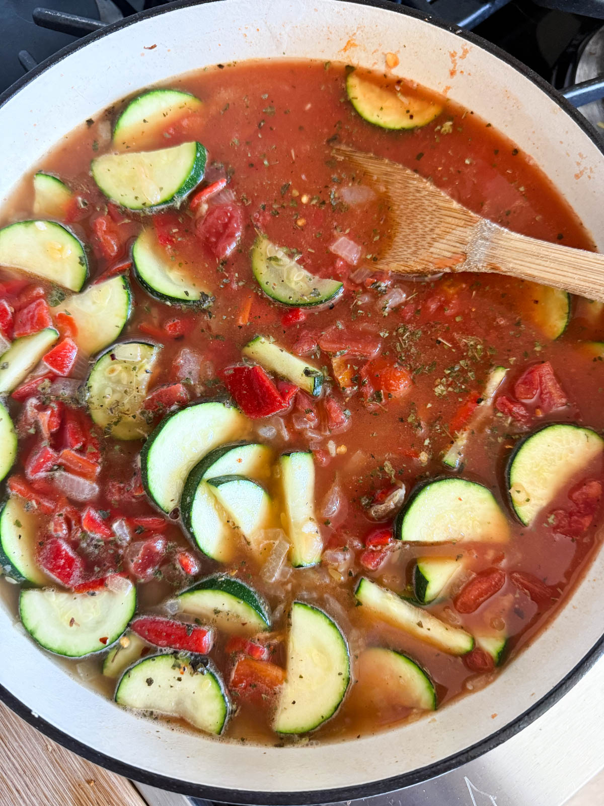 roasted red peppers and tomatoes added to the pan of veggies and orzo