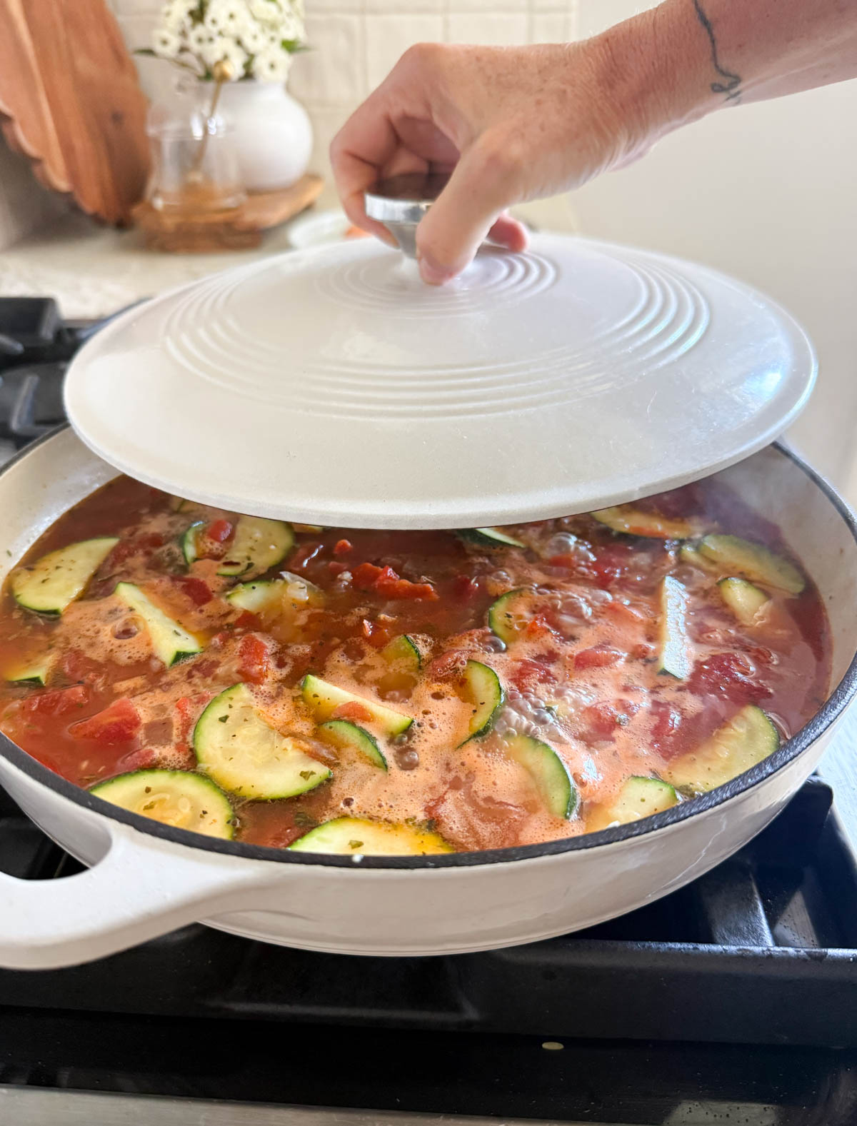 orzo and veggies being covered in a pan