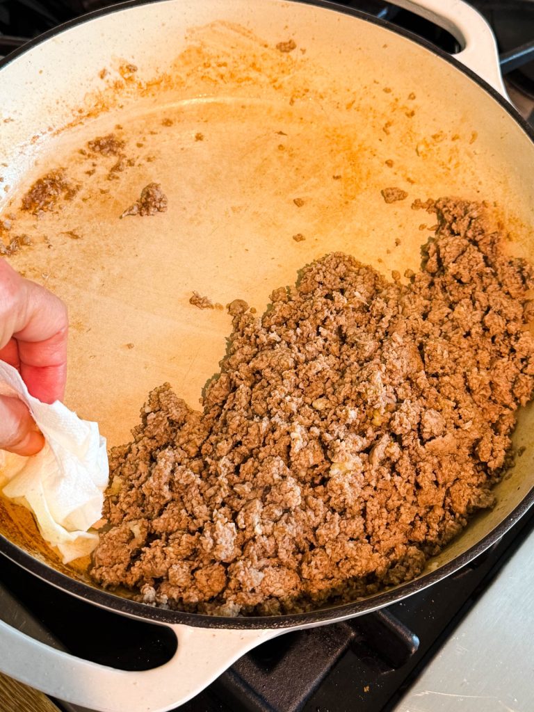 draining the excess liquid out of the skillet after cooking ground turkey