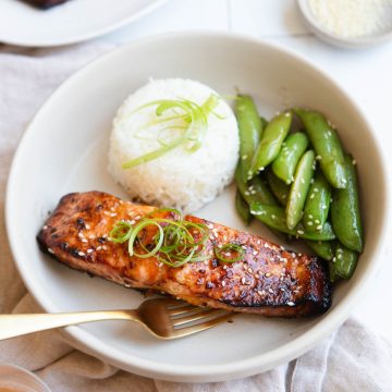 air fryer miso glazed salmon next to a bowl of rice and sugar snap peas