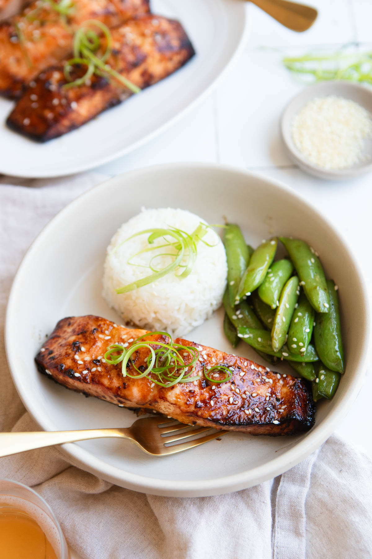 miso glazed salmon filet cooked in the air fryer, set next to charred sugar snap peas and rice