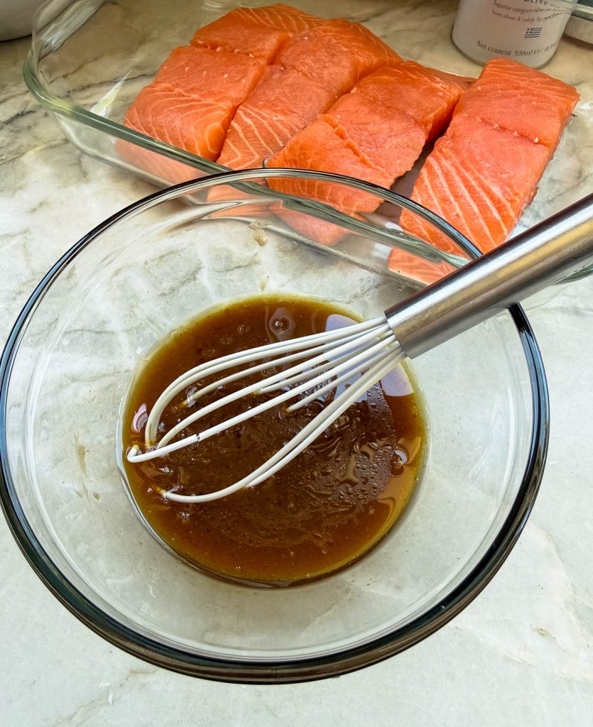 miso marinade in a glass bowl and whisk getting ready to top on salmon filets