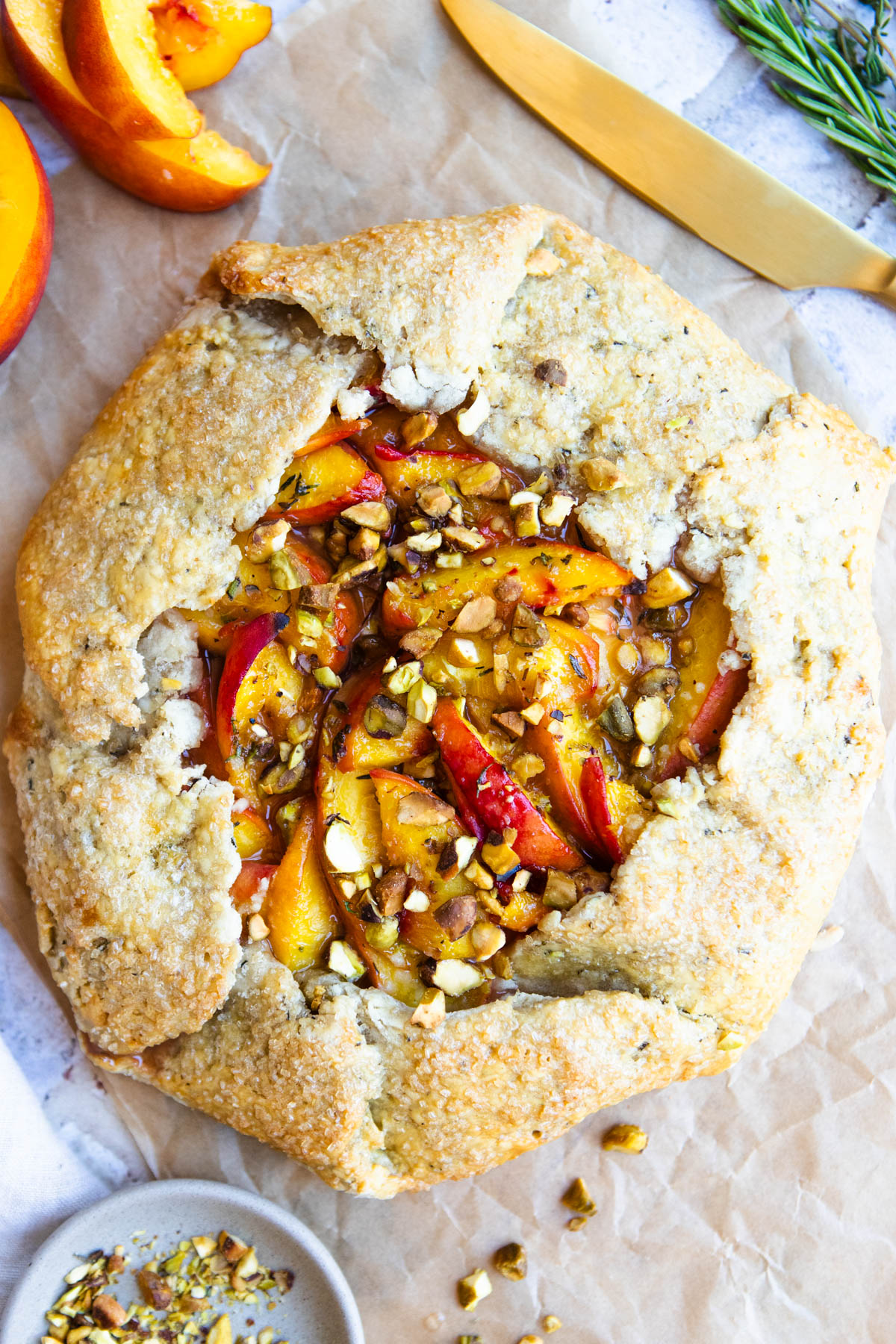 baked peach galette ready to be sliced and drizzled with honey