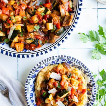 a large bowl filled with stovetop ratatouille and also a smaller bowl filled with creamy polenta and ratatouille on top