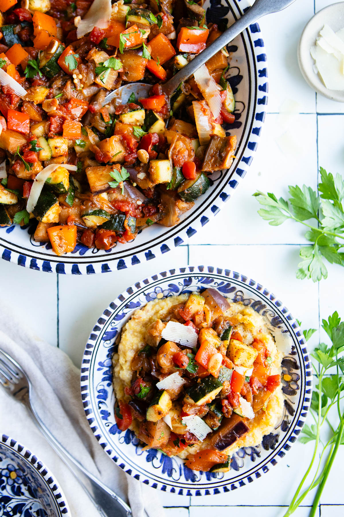a large bowl filled with stovetop ratatouille and also a smaller bowl filled with creamy polenta and ratatouille on top