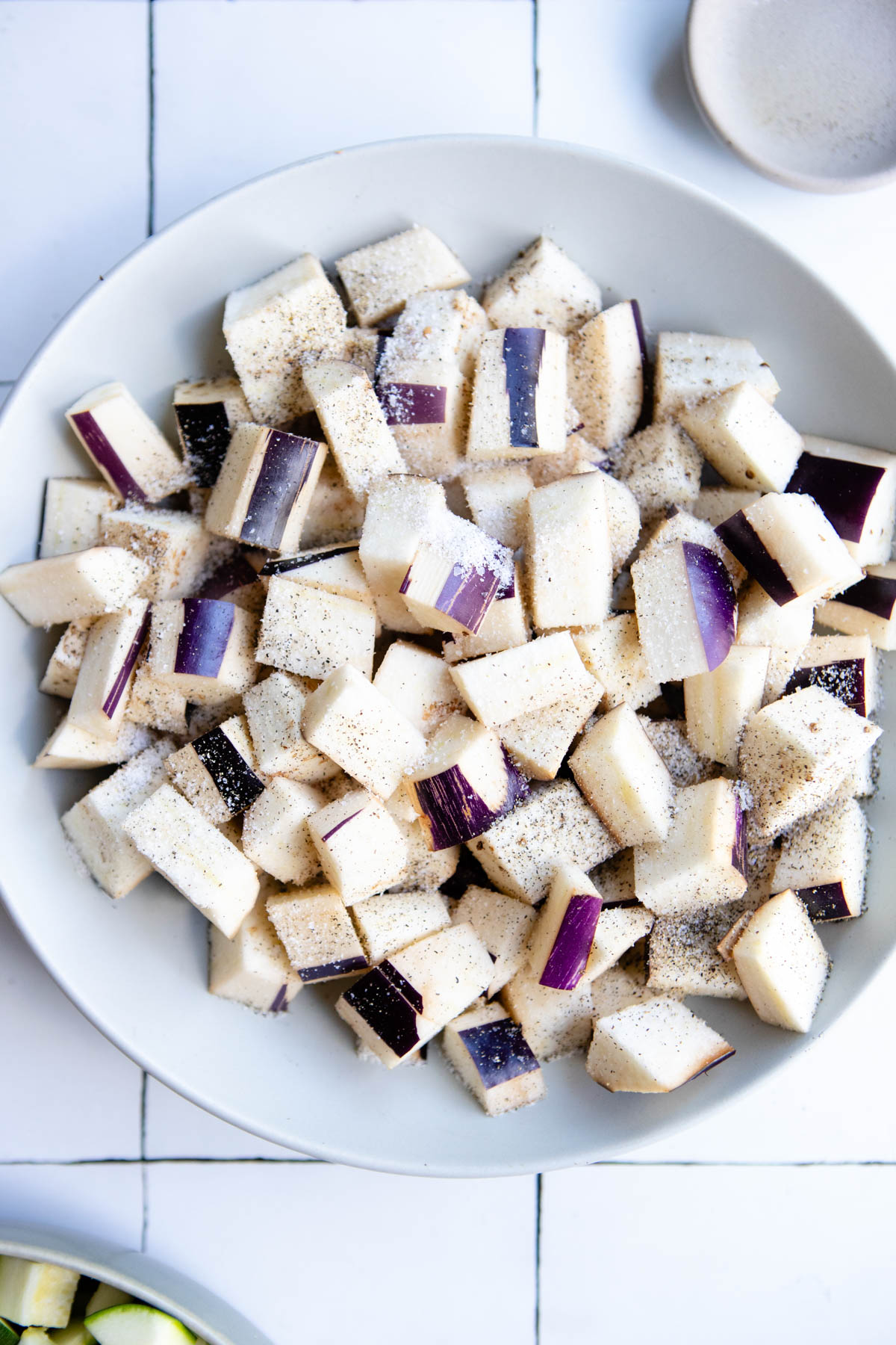 raw eggplant that has been salted and cubed, resting in a bowl
