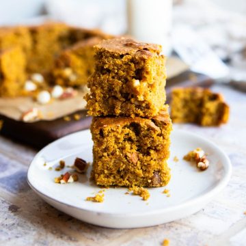 2 pumpkin bars stacked on each other set on a white ceramic plate