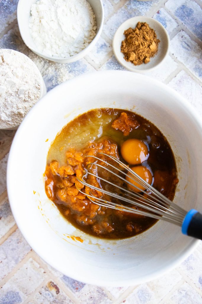 wet ingredients being mixed in a bowl to make pumpkin blondies