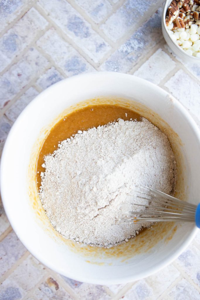 dry ingredients being added to wet ingredients to make healthy pumpkin bars